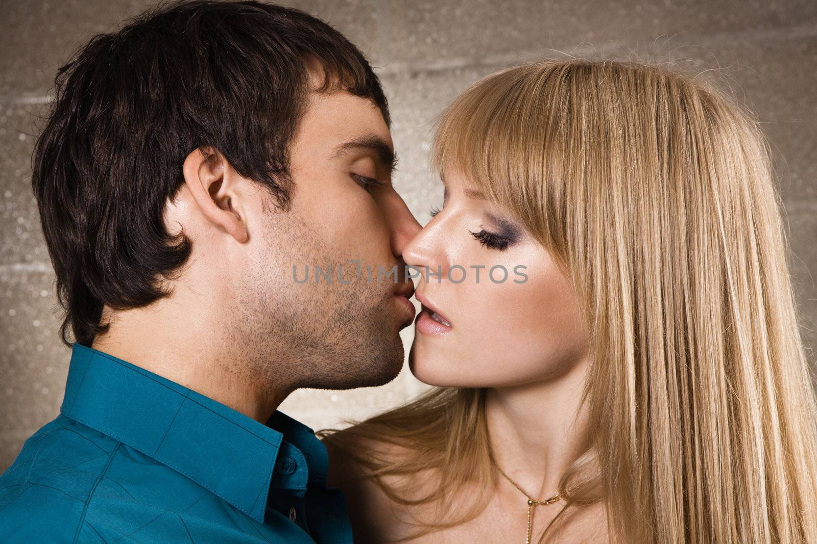 Young romantic couple kissing in house interior