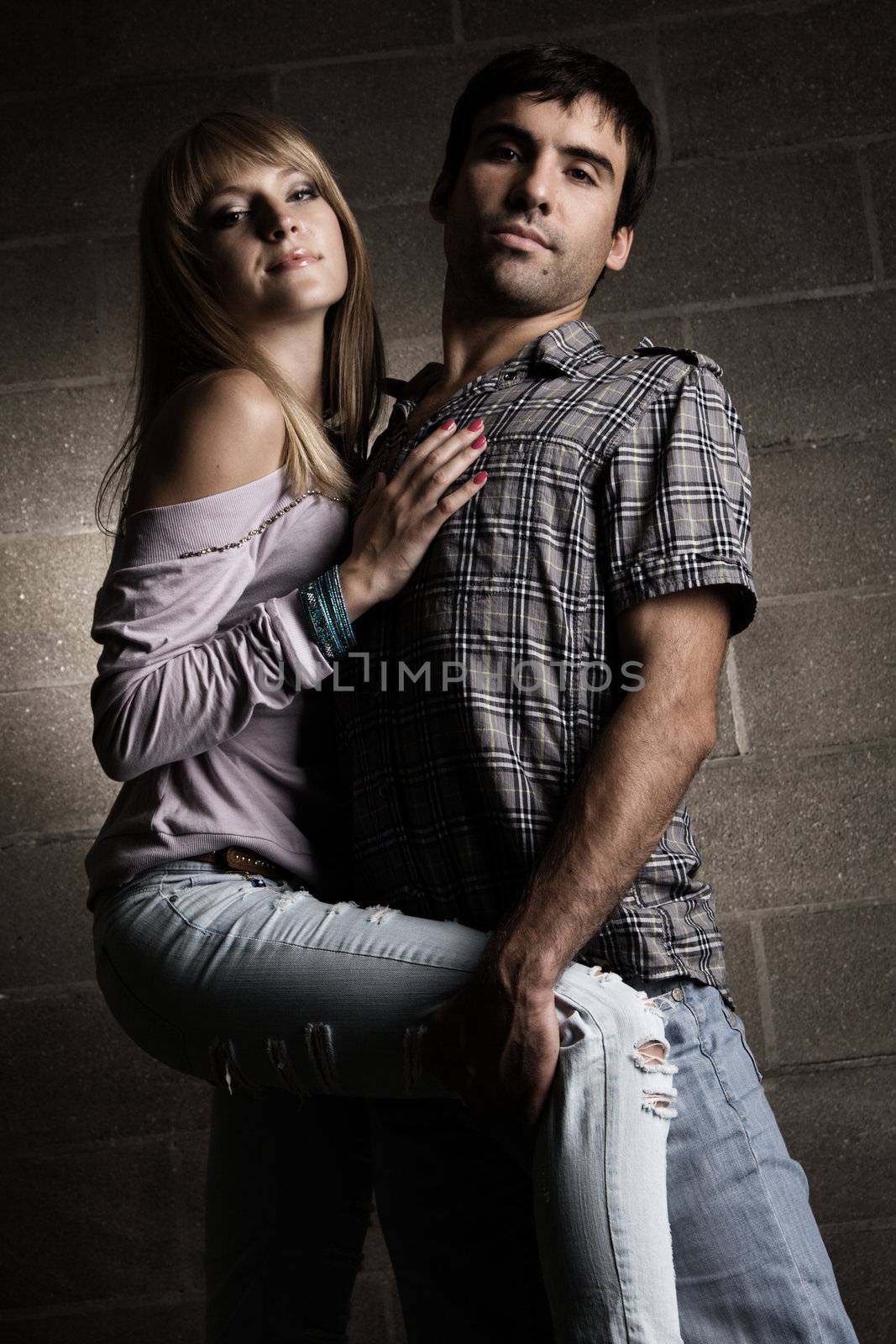 Young cheerful couple on brick wall background