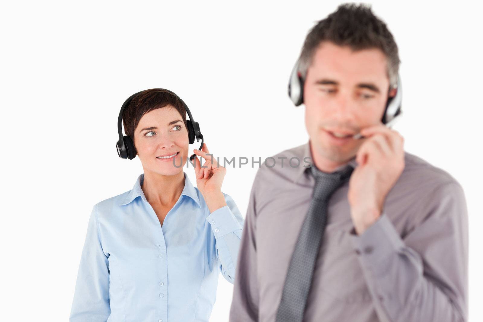 Business people speaking through headsets against a white background