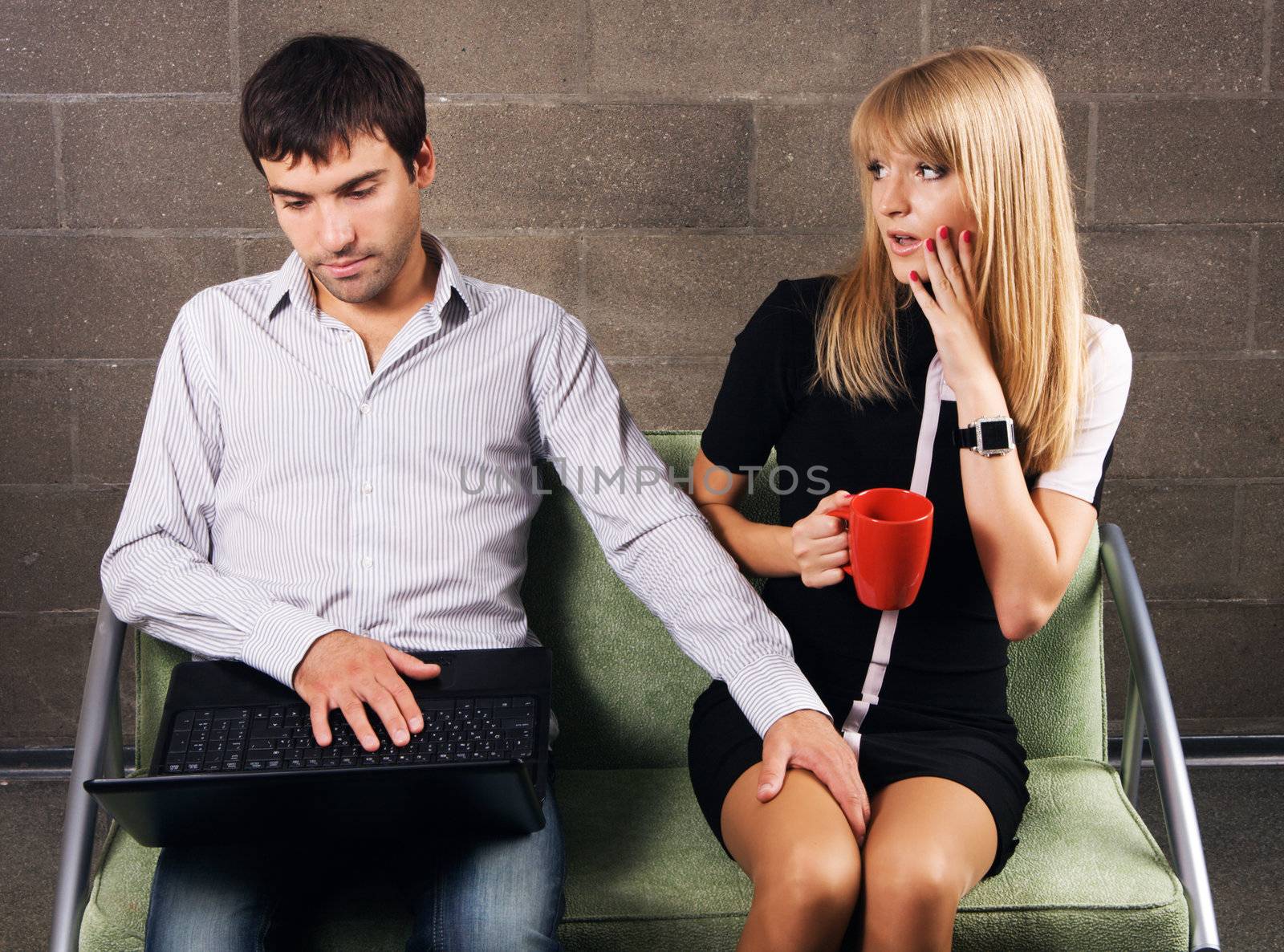 Young man and woman sitting with a laptop indoors 