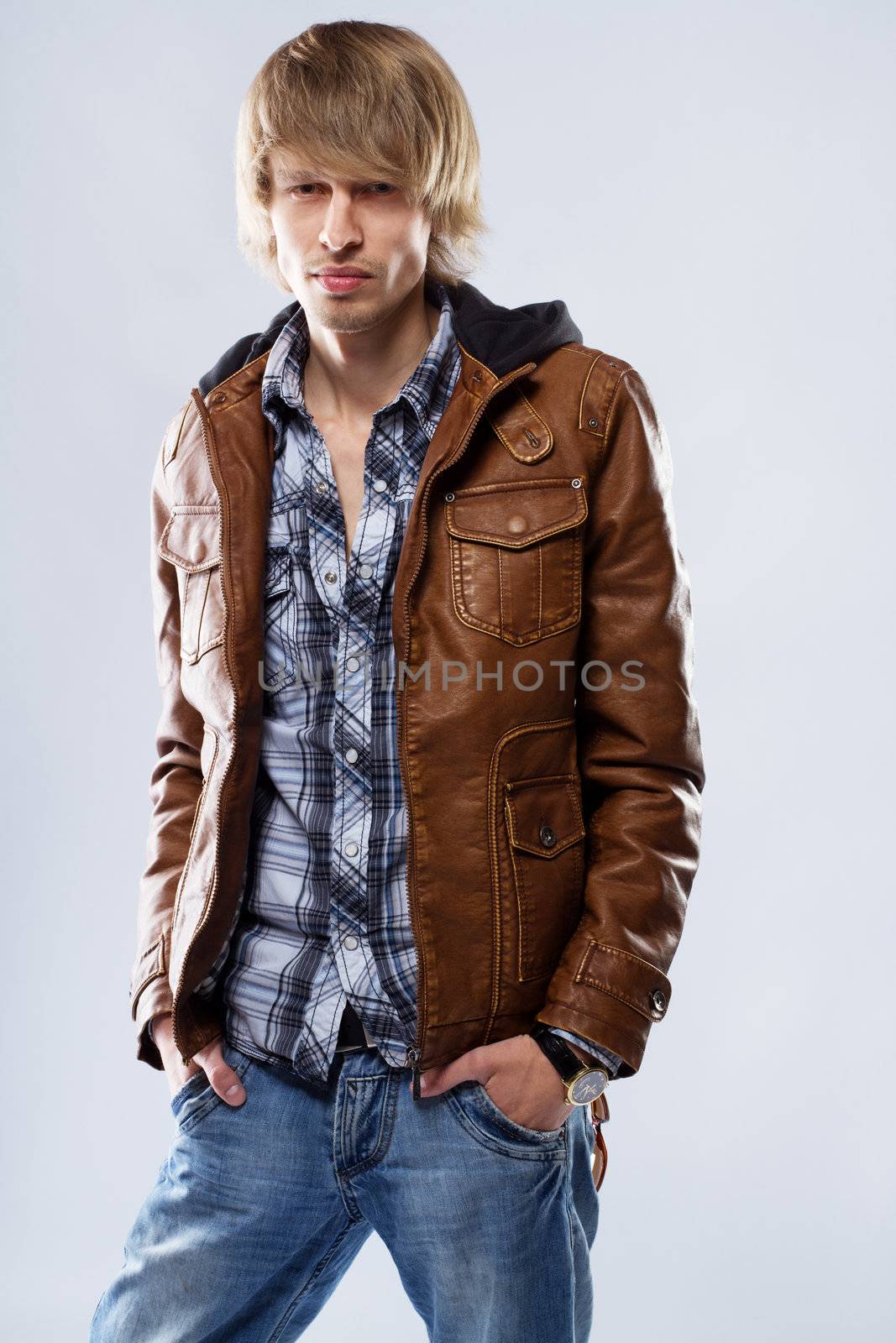 Handsome young man in leather jacket, studio portrait