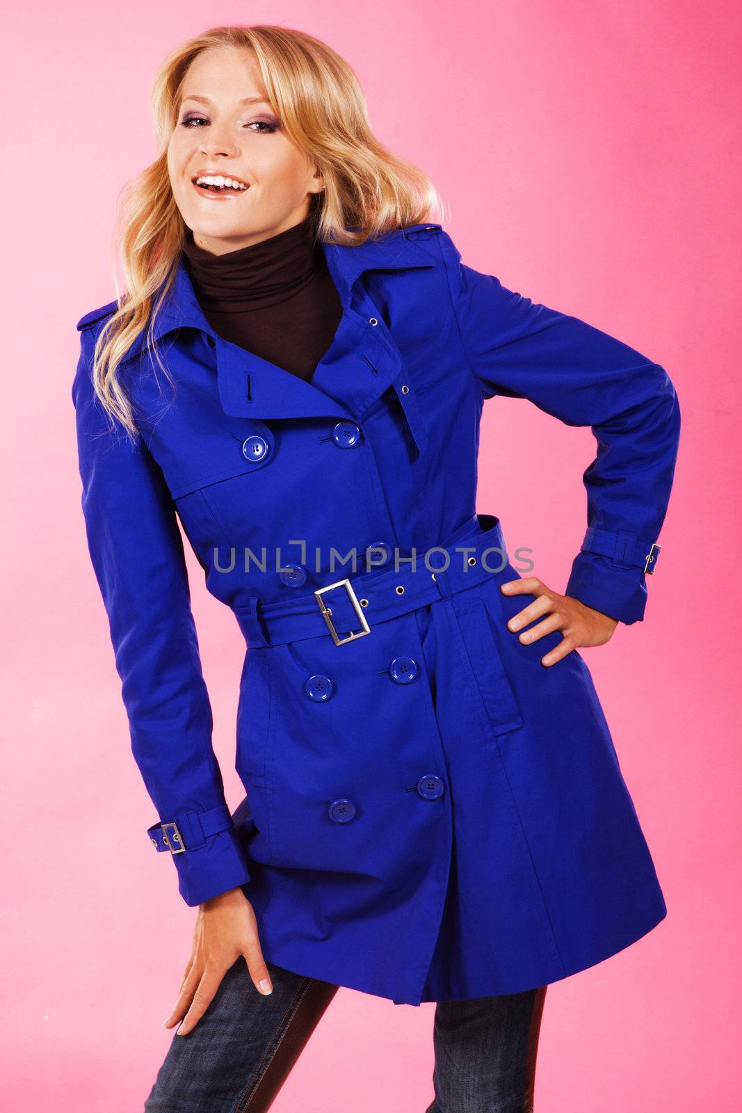 Lovely woman in a blue coat against pink background