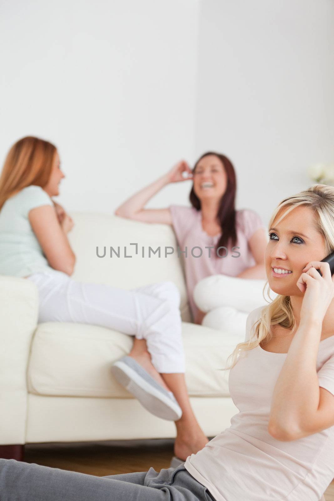 Joyful woman with a phone separated from the others by Wavebreakmedia