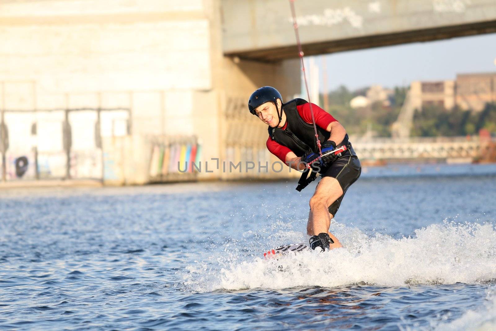 Wakeboarder surfing across the river