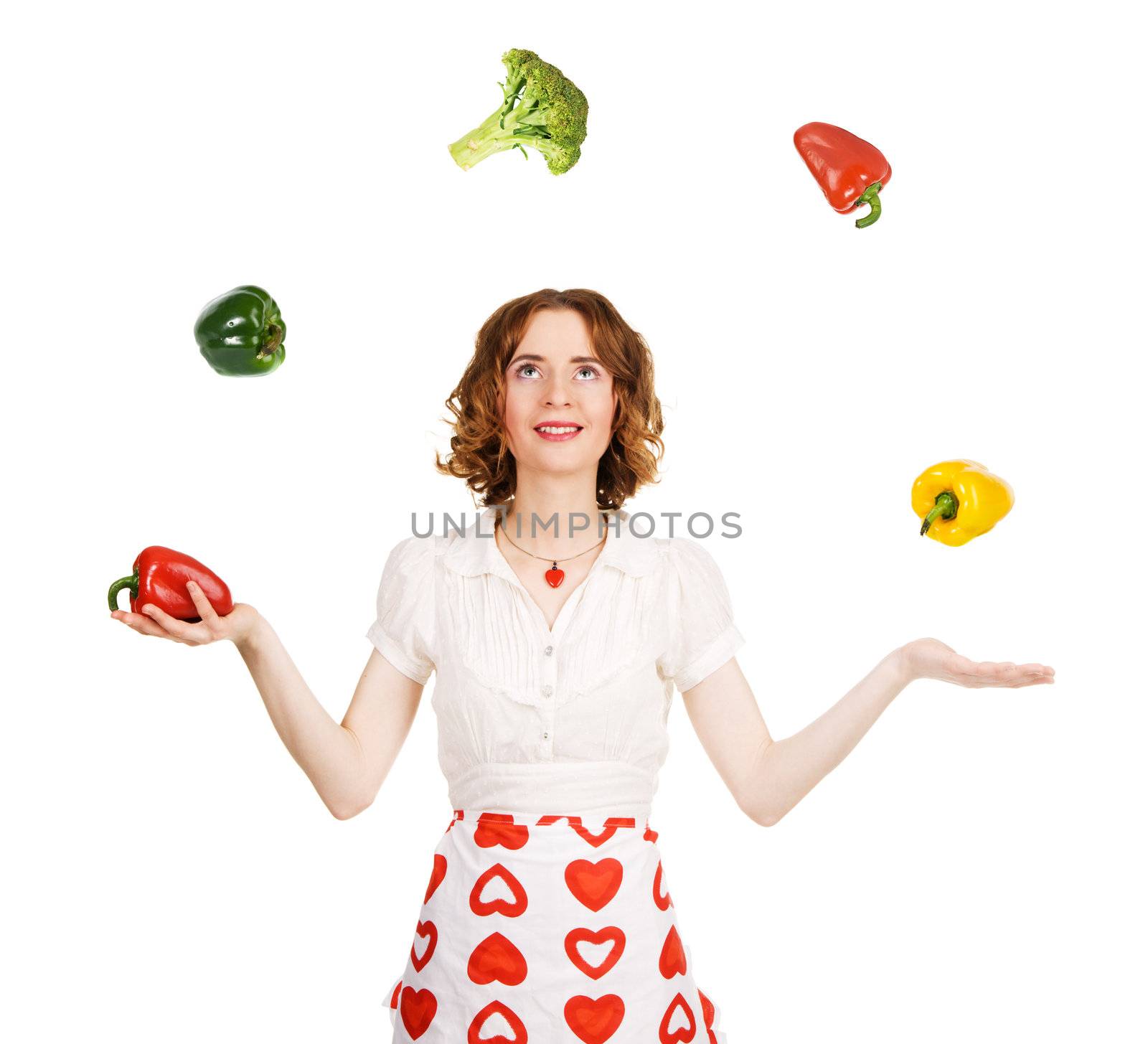 Young beautiful woman juggling with vegetables, white background