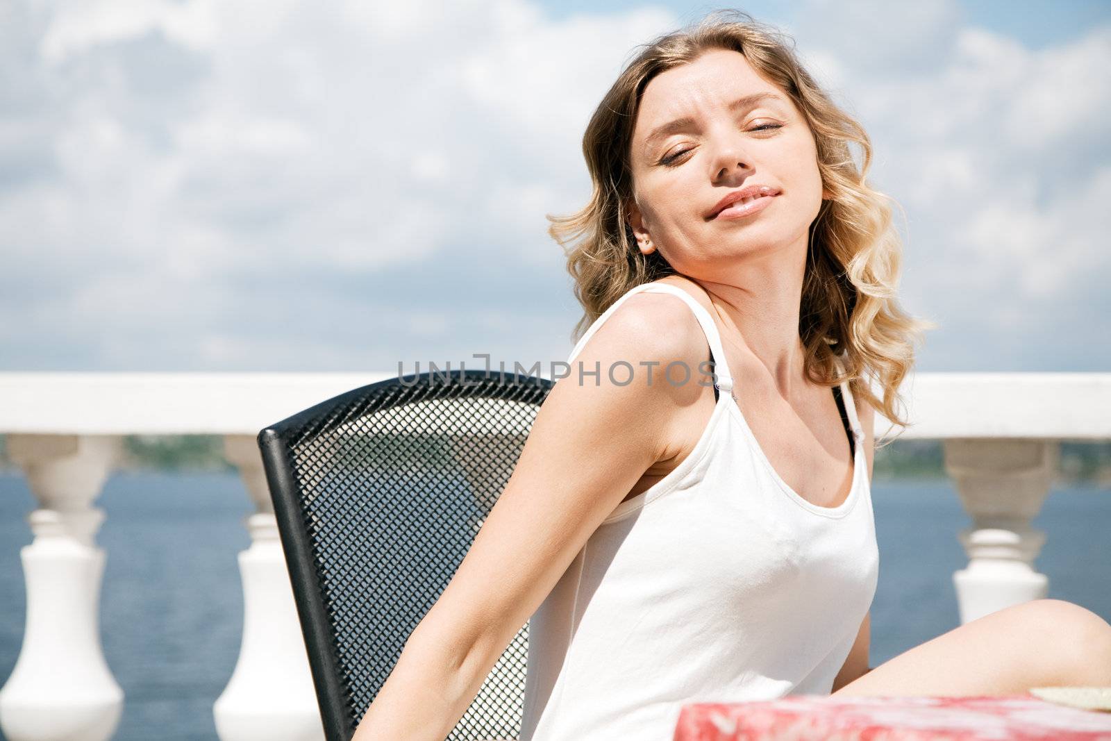 Beautiful lady in an outdoor cafe at hte seaside