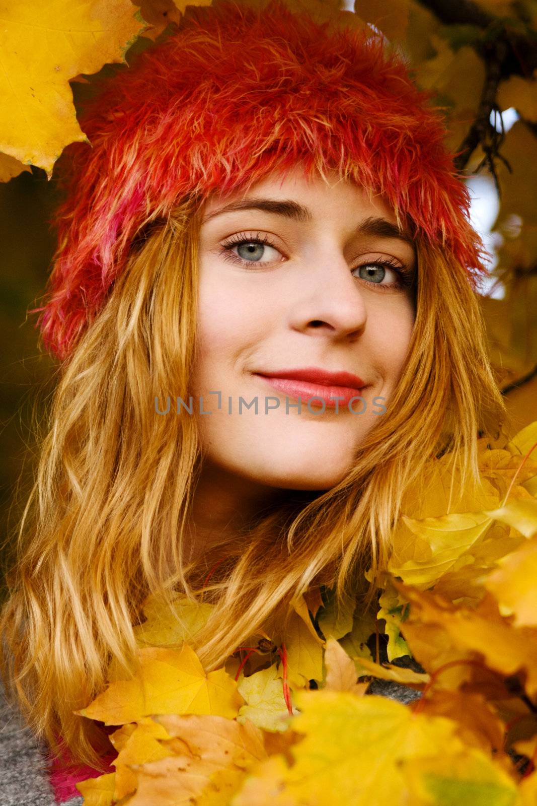 Beautiful young woman among yellow leaves by Gdolgikh