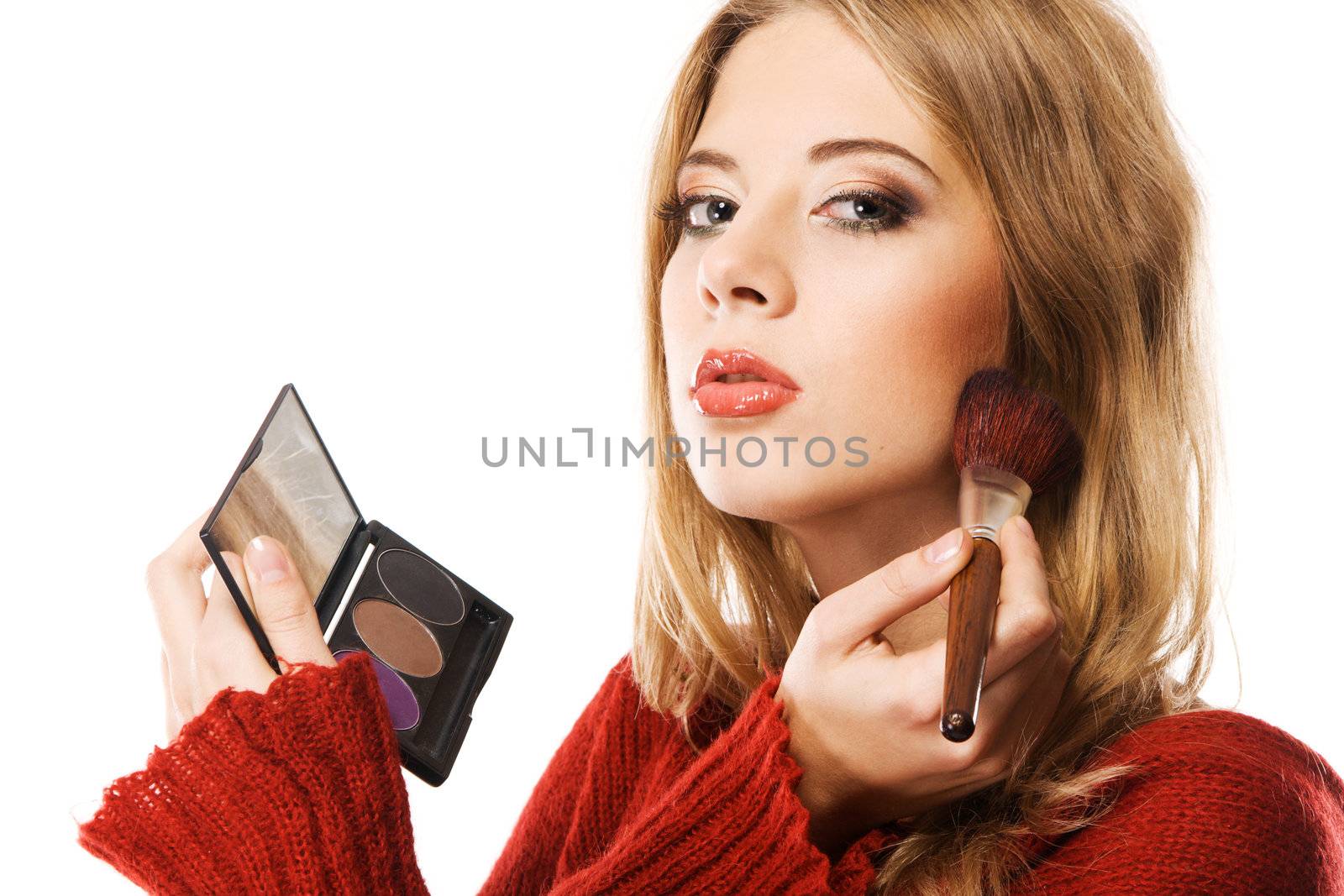 Portrait of attractive young woman applying blusher 