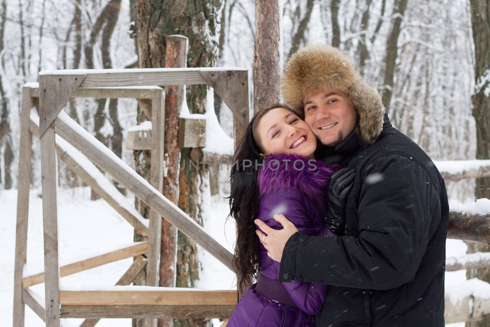 Portrait of a young happy couple in winter park