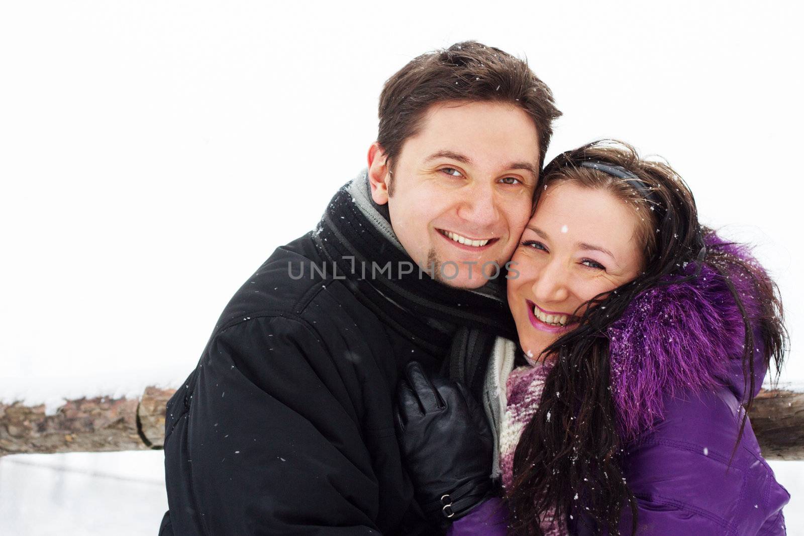 Young happy couple having fun in winter park 