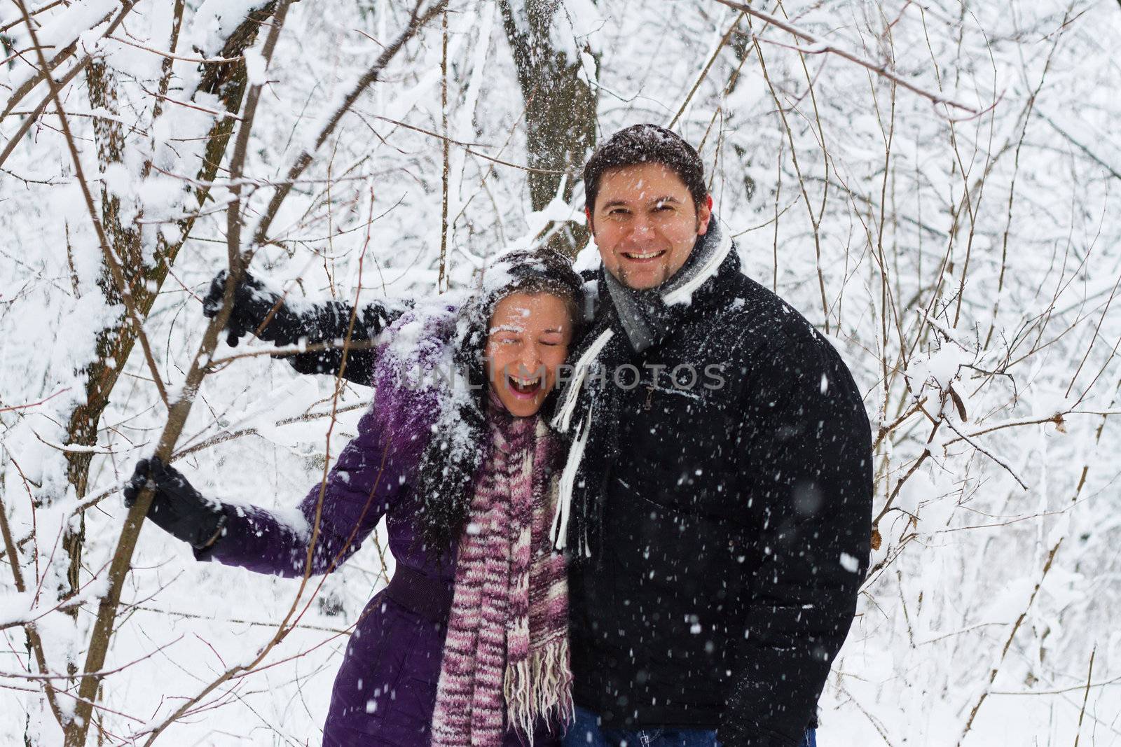 Portrait of young couple having fun in winter park 