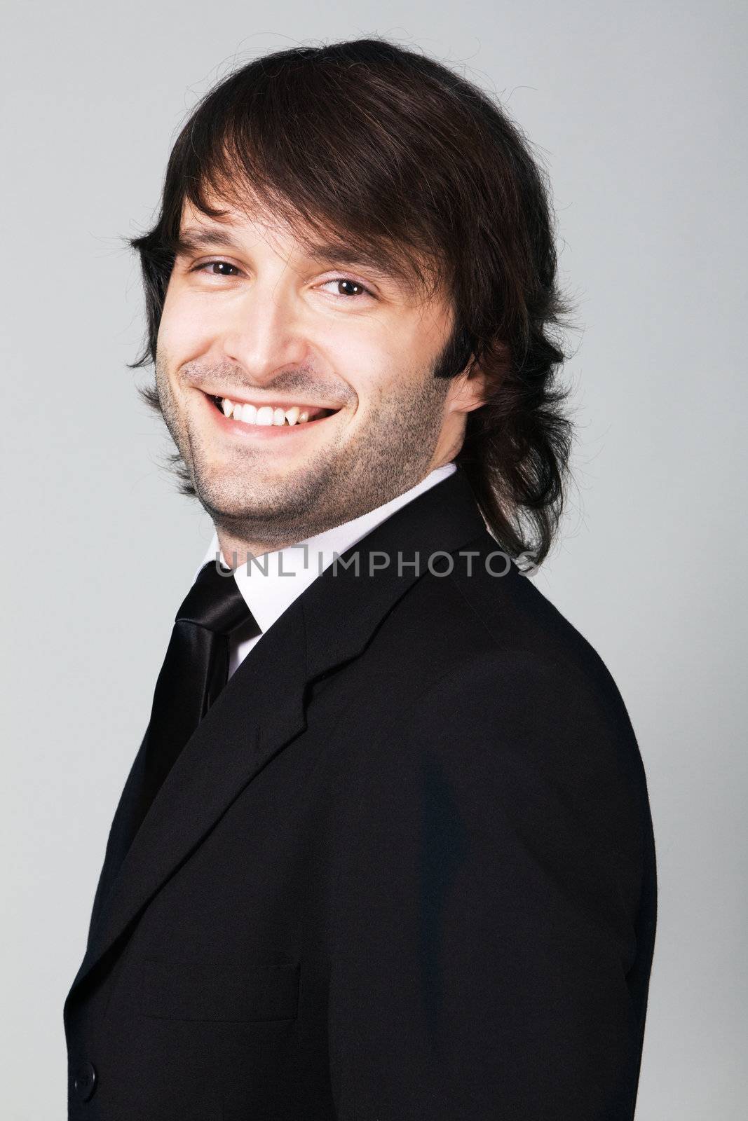 Portrait of a cheerful elegant businessman against gray background