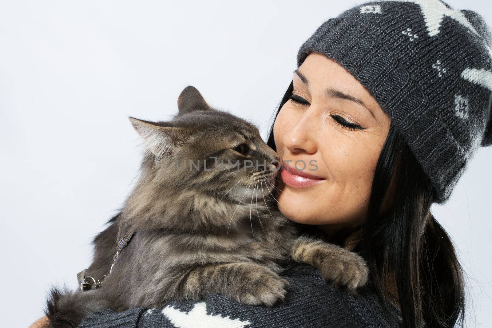 Young lady with a cat, studio photo on neutral backgrund