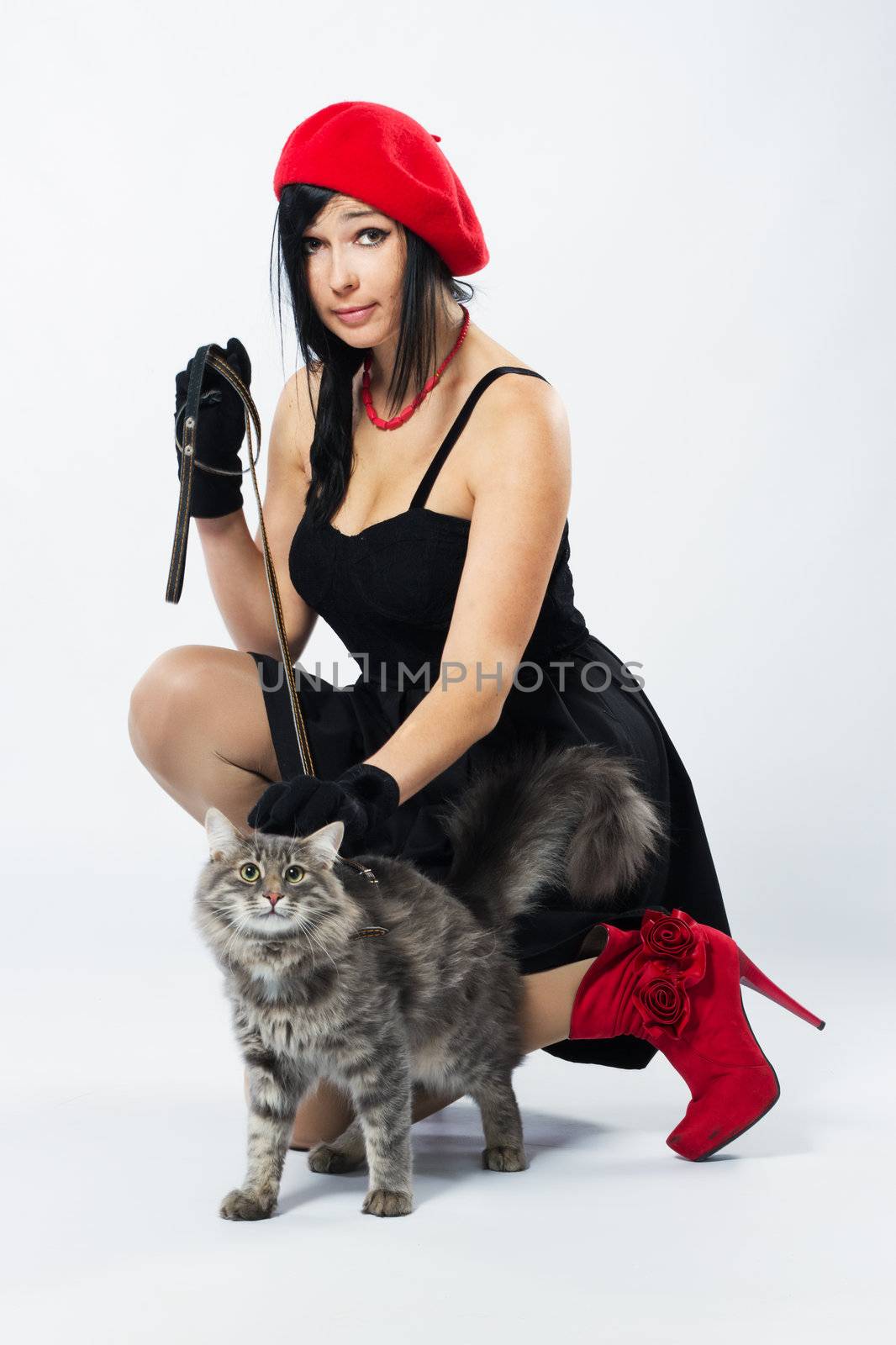 Young lady with a cat, studio photo on neutral backgrund