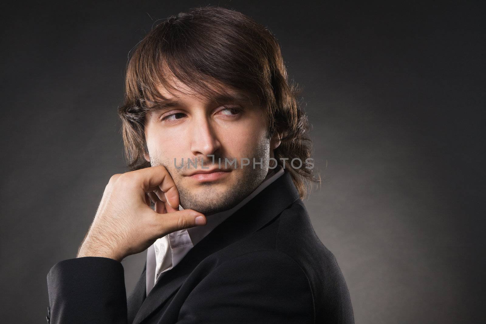 Handsome man against black background by Gdolgikh