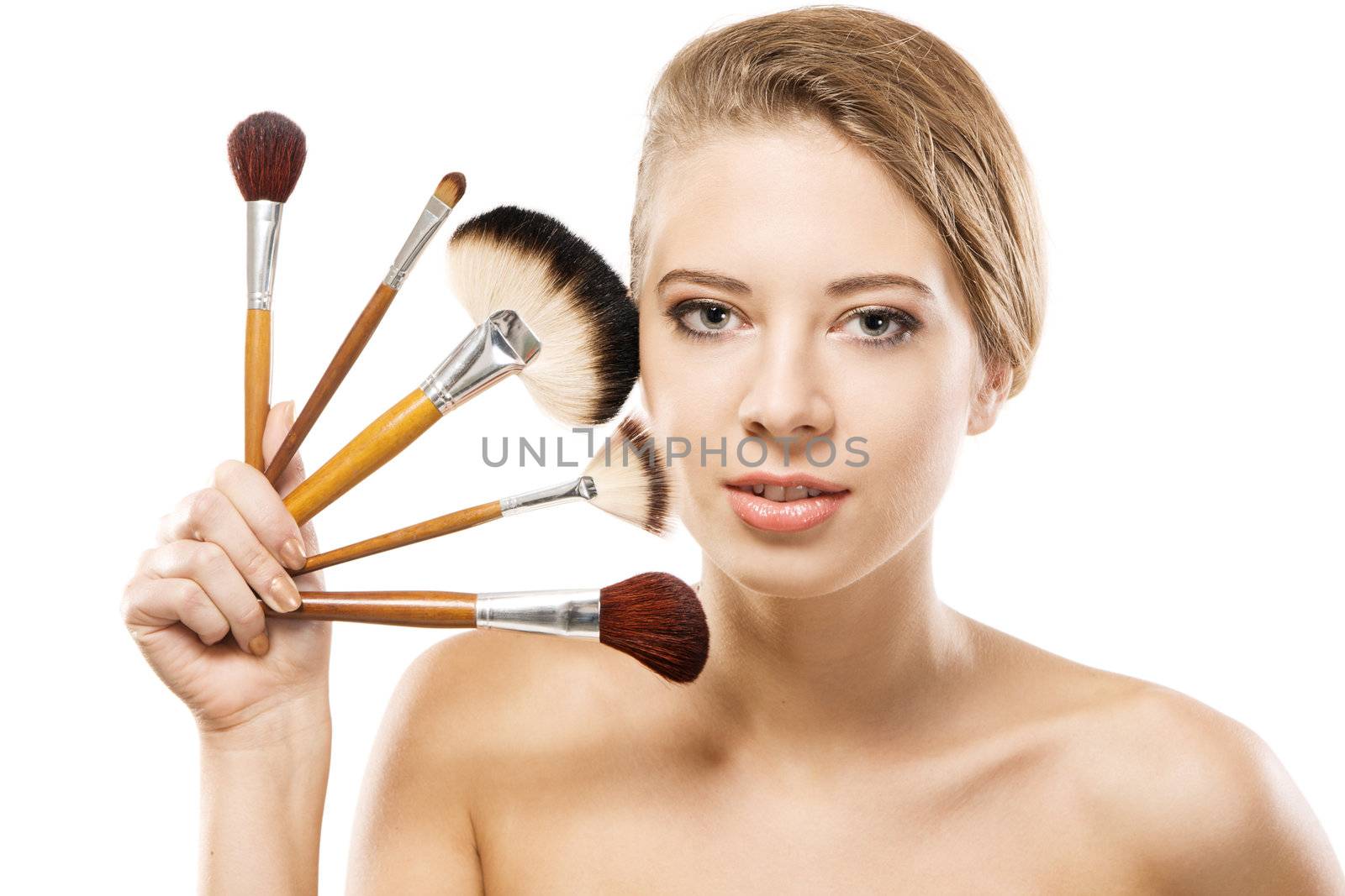 Portrait of a beautiful young woman with makeup brushes 