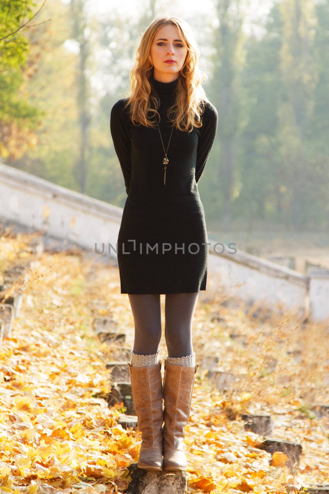 Young beautiful lady in an autumn park by Gdolgikh