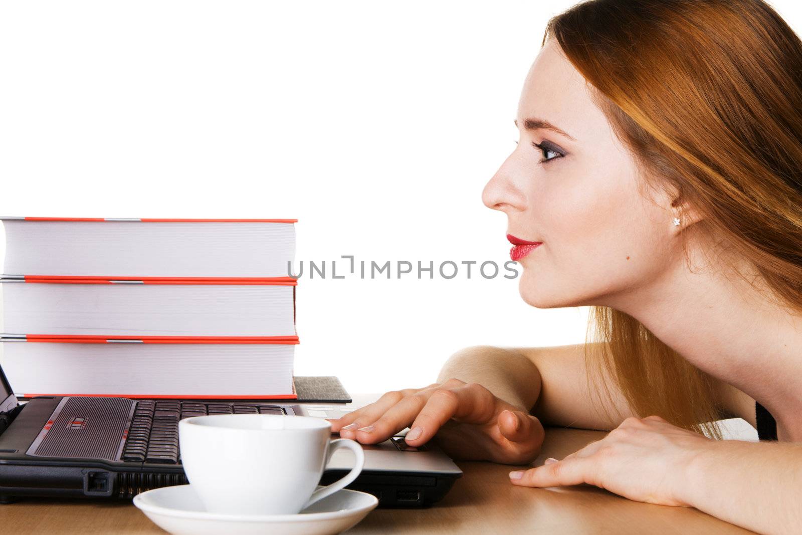Young woman with laptop, books and cup of coffee