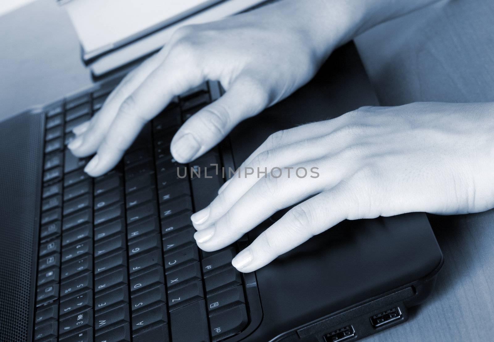 Hands of a woman working at her laptop by Gdolgikh