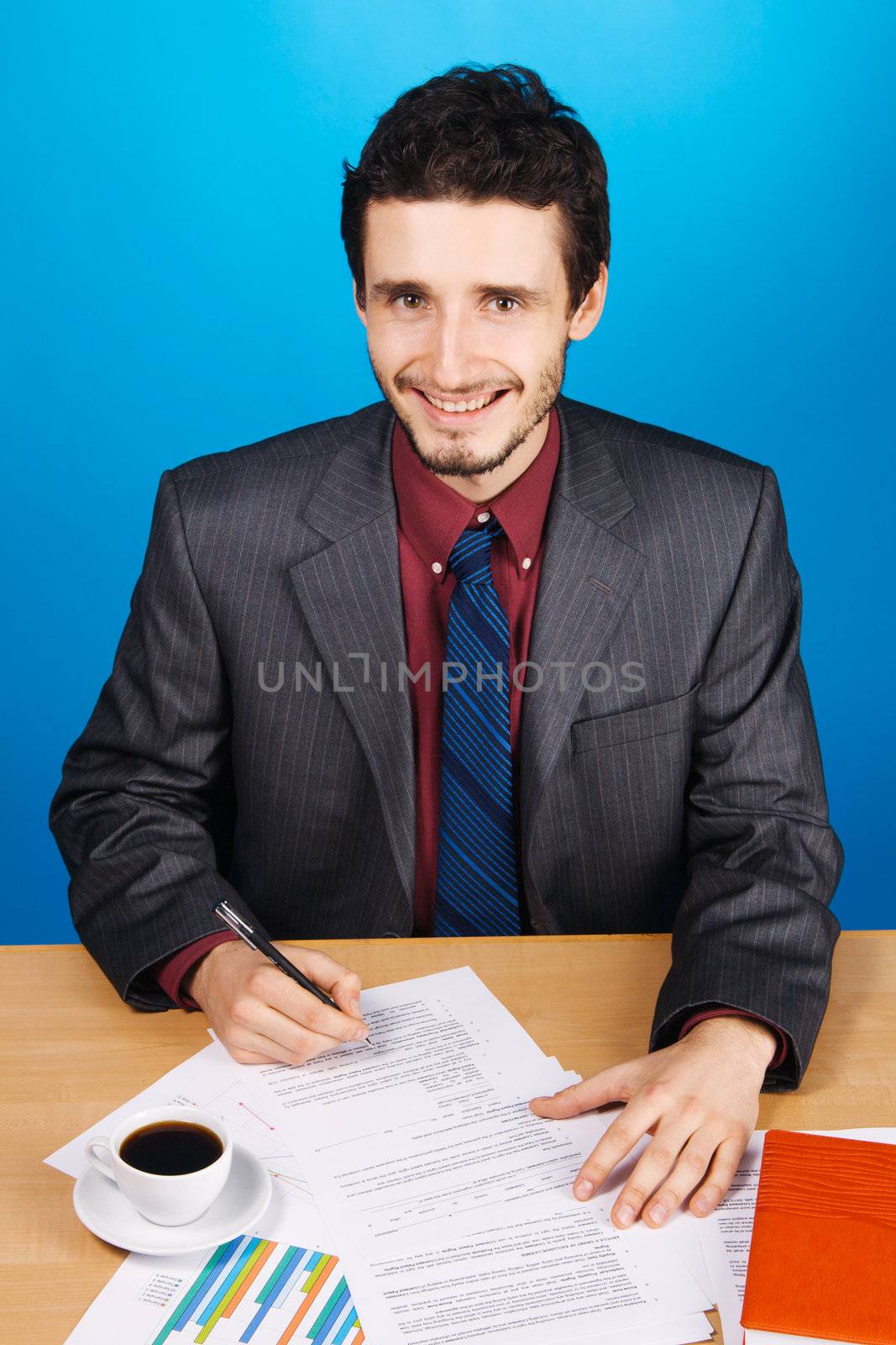 Young handsome businessman working with documents by Gdolgikh