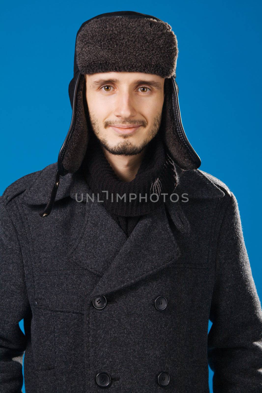 Handsome young man in winter clothing by Gdolgikh