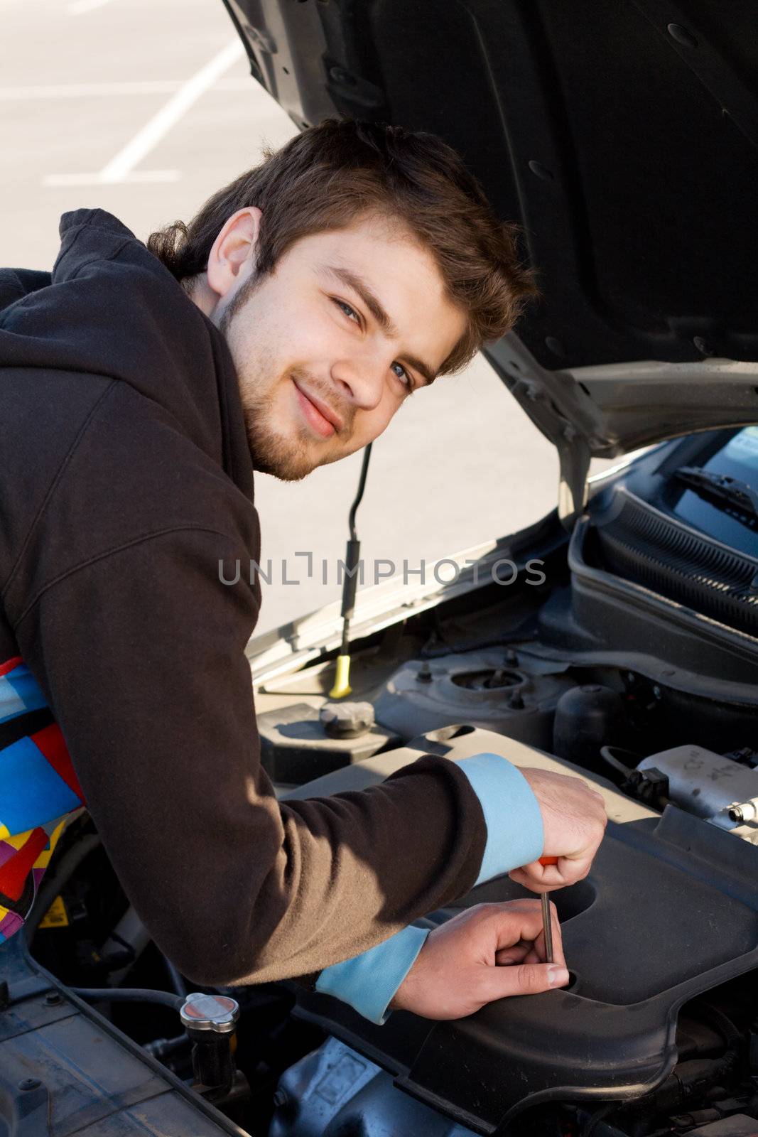 Car driver examining the car's engine by Gdolgikh