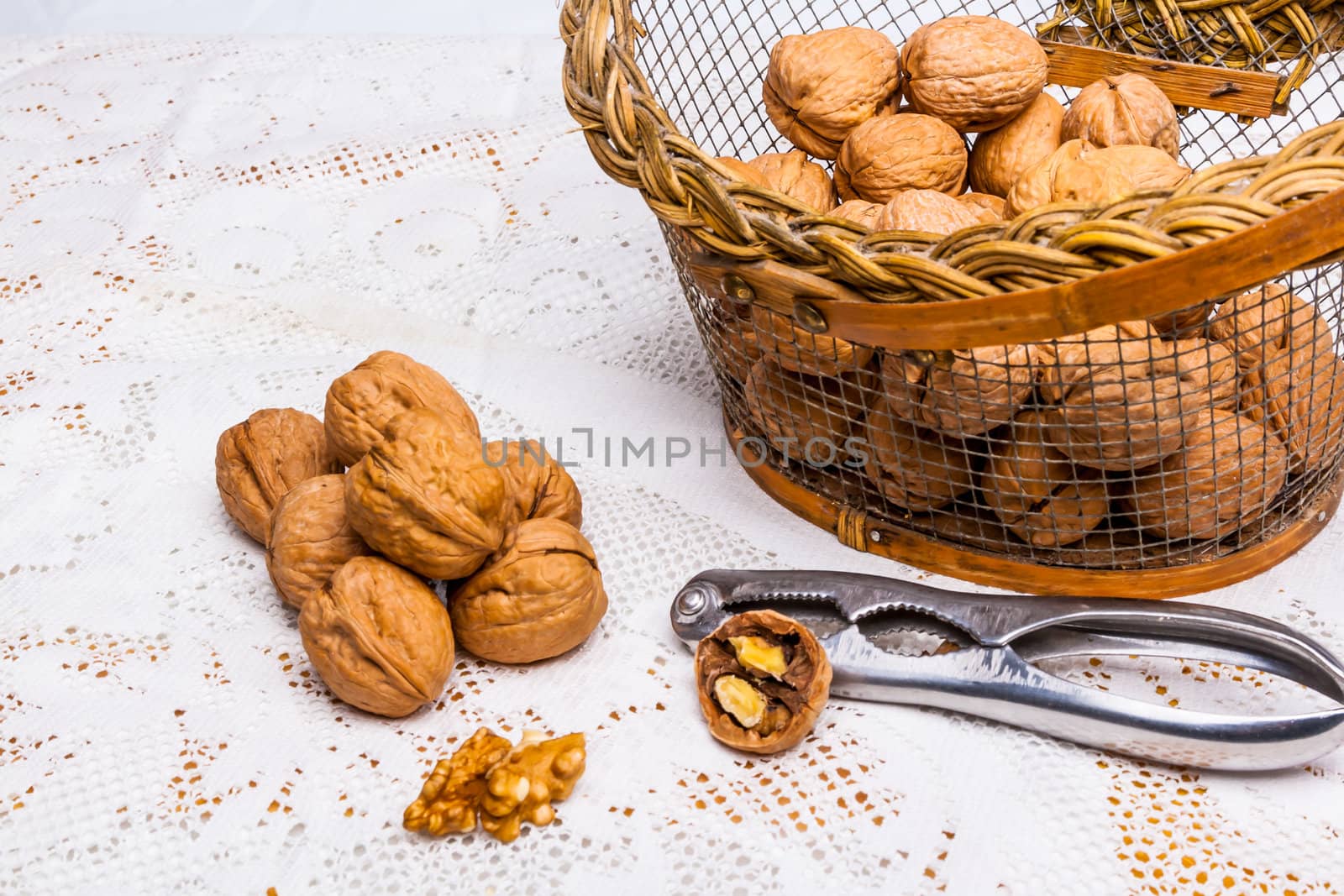 A composition of walnuts, cracked walnuts and a nutcraker
