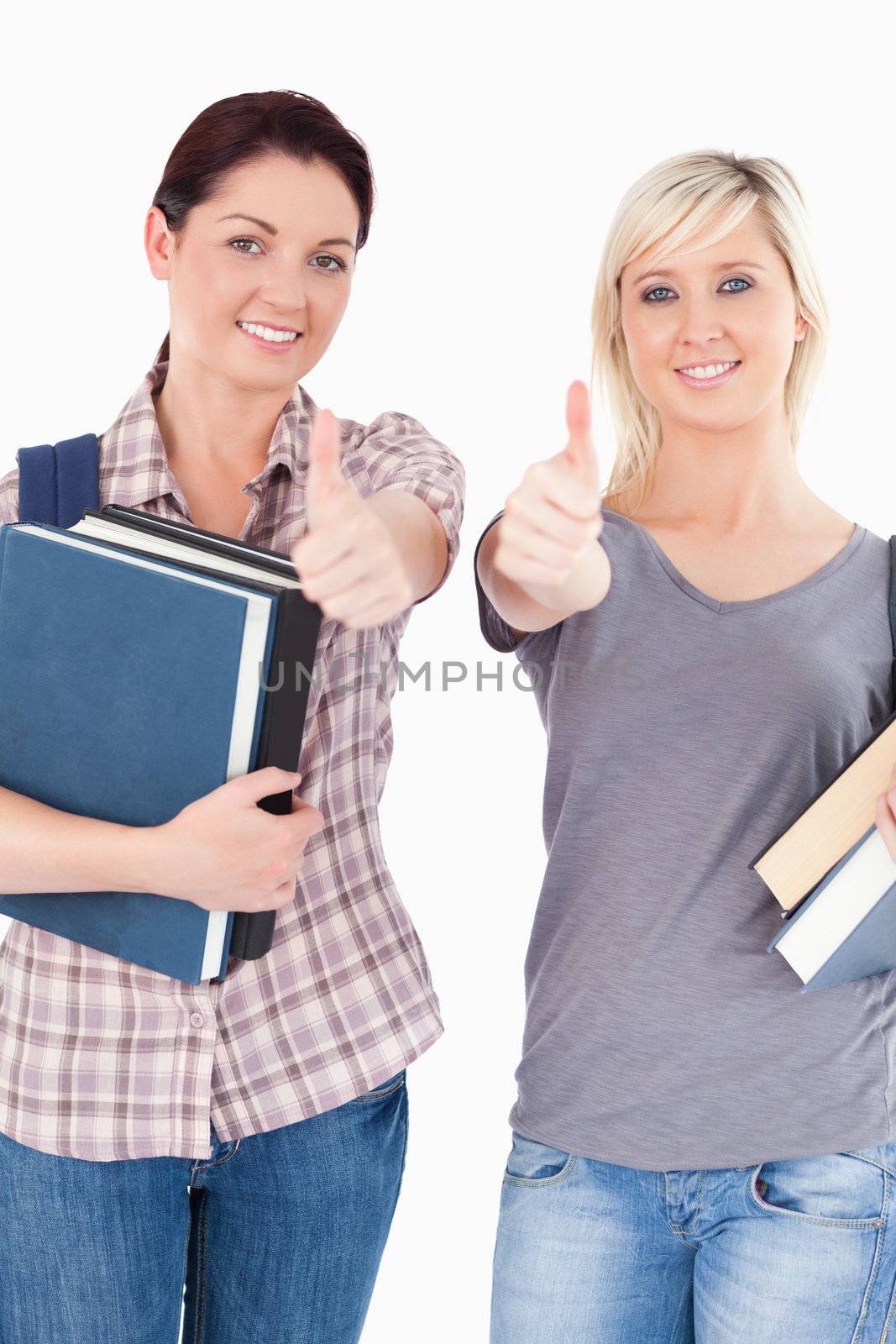 Two gorgeous students with books and thumbs up