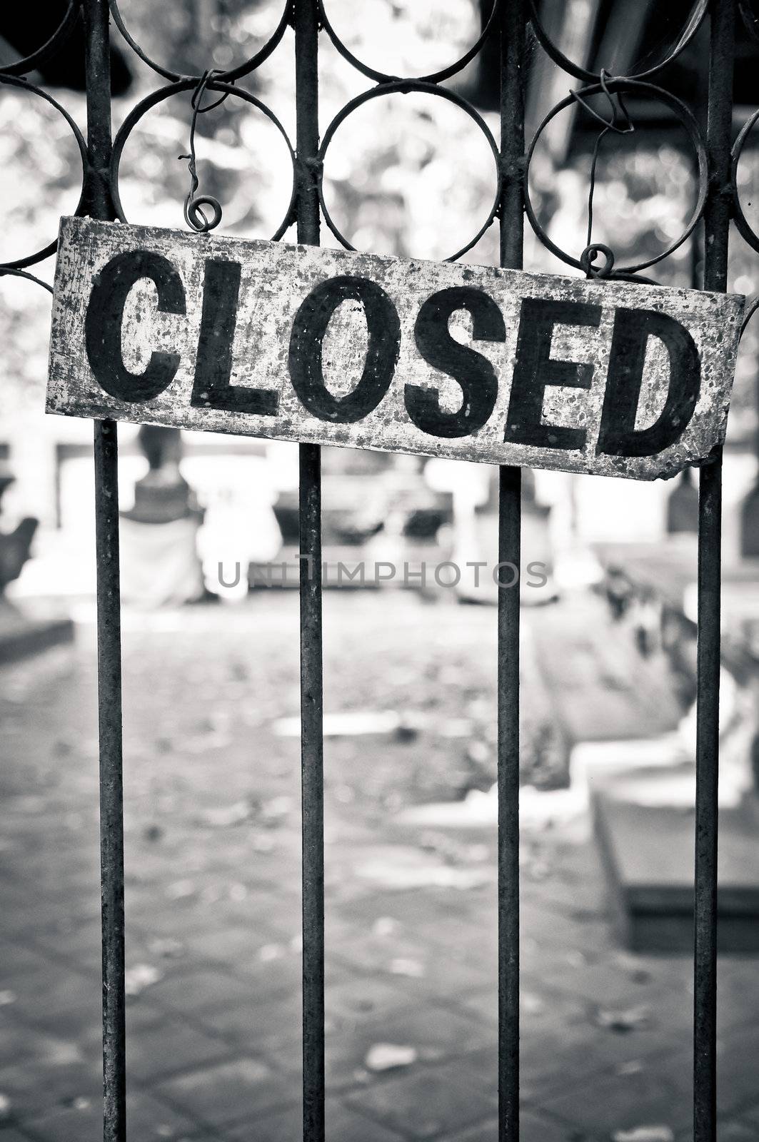 Monochrome closed sign on metal bars of the gate