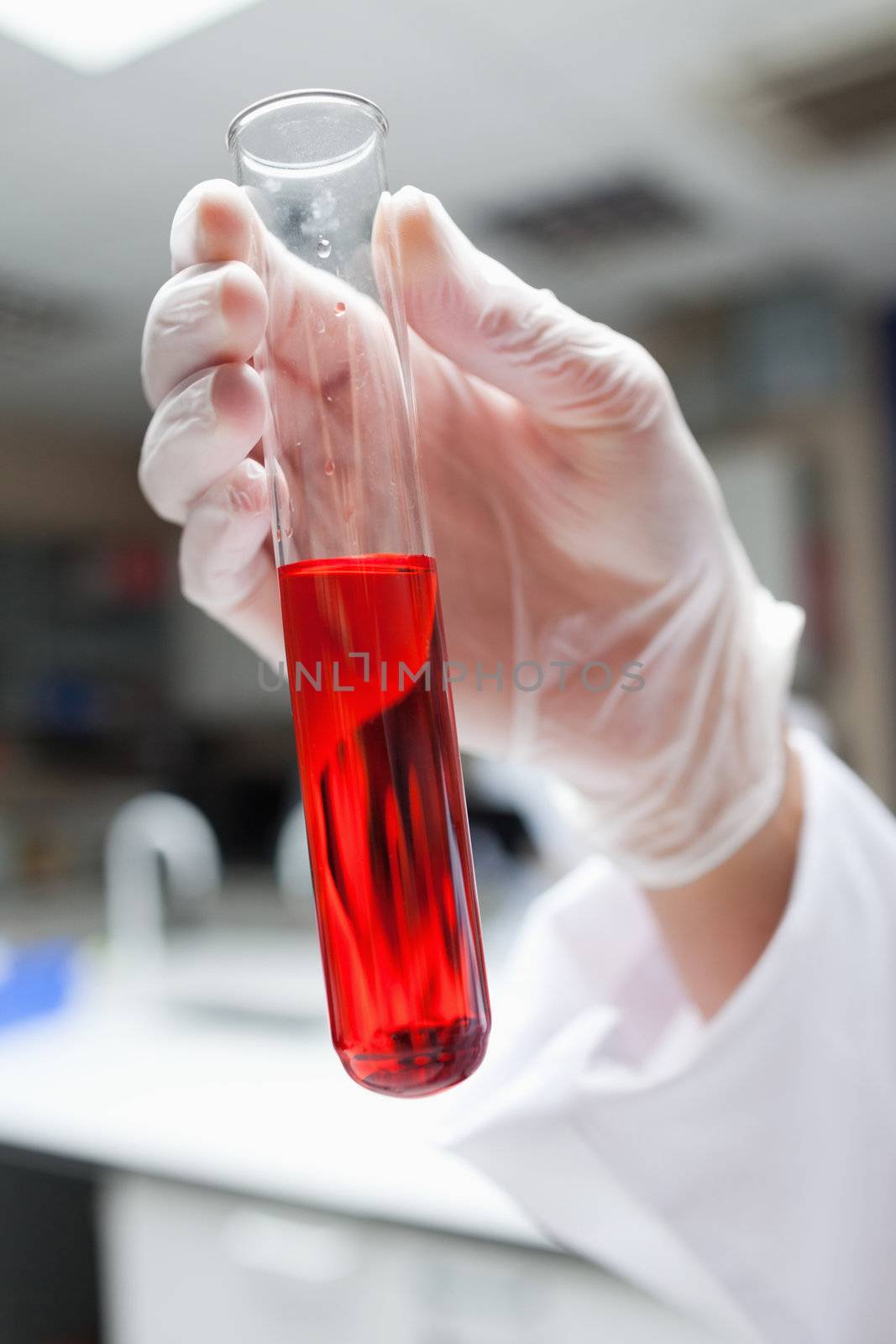 Portrait of a test tube filled in with a red liquid