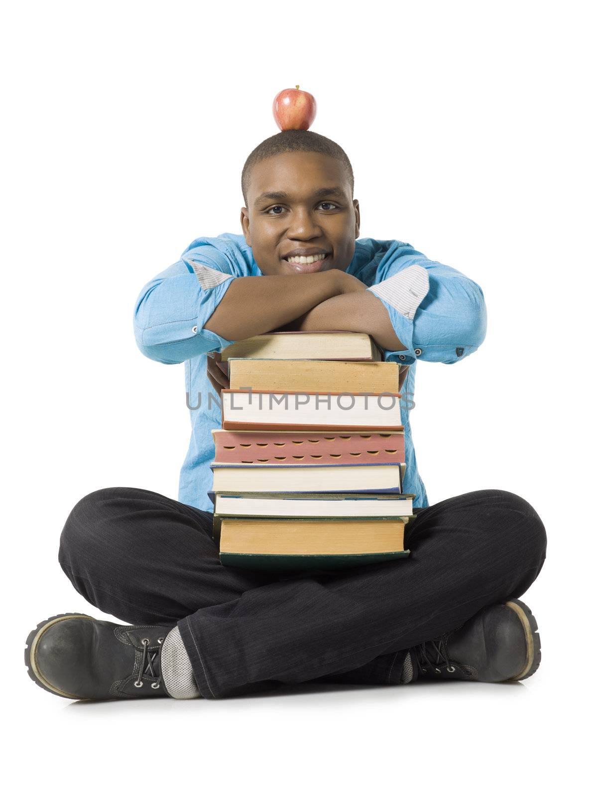 Portrait of teenage guy with stack of books and apple against white background