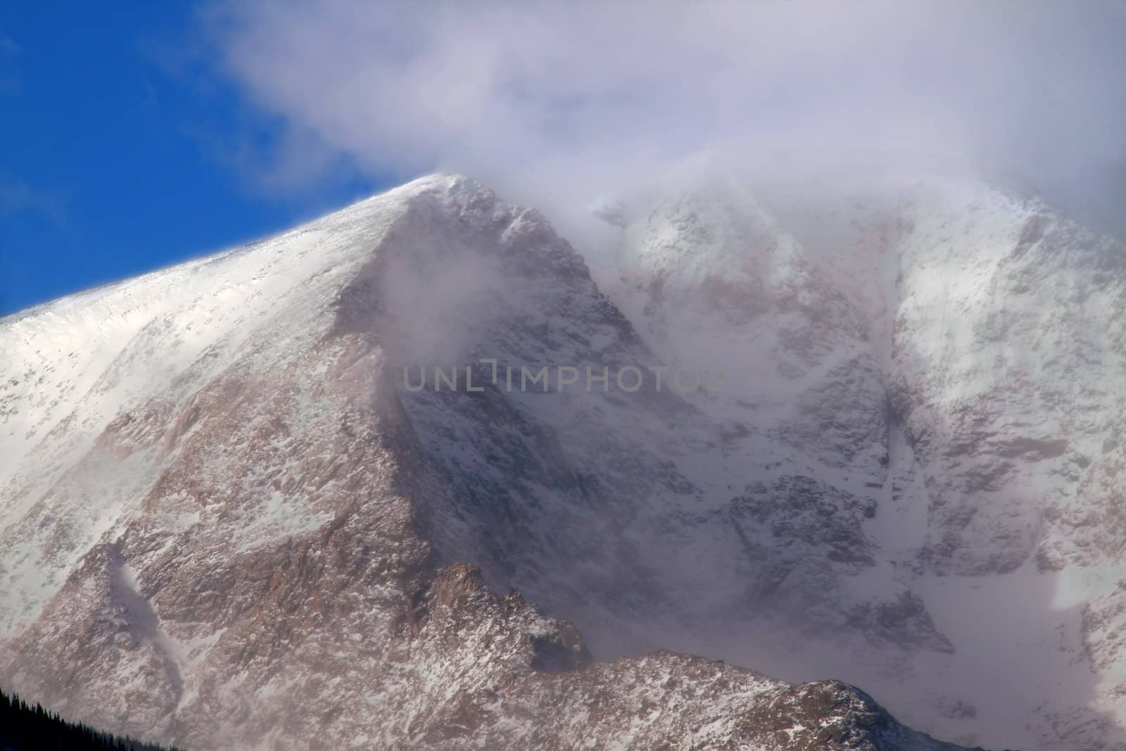 Intense winds create a fog of snow over Mount Ypsilon of Rocky Mountain National Park in Colorado.