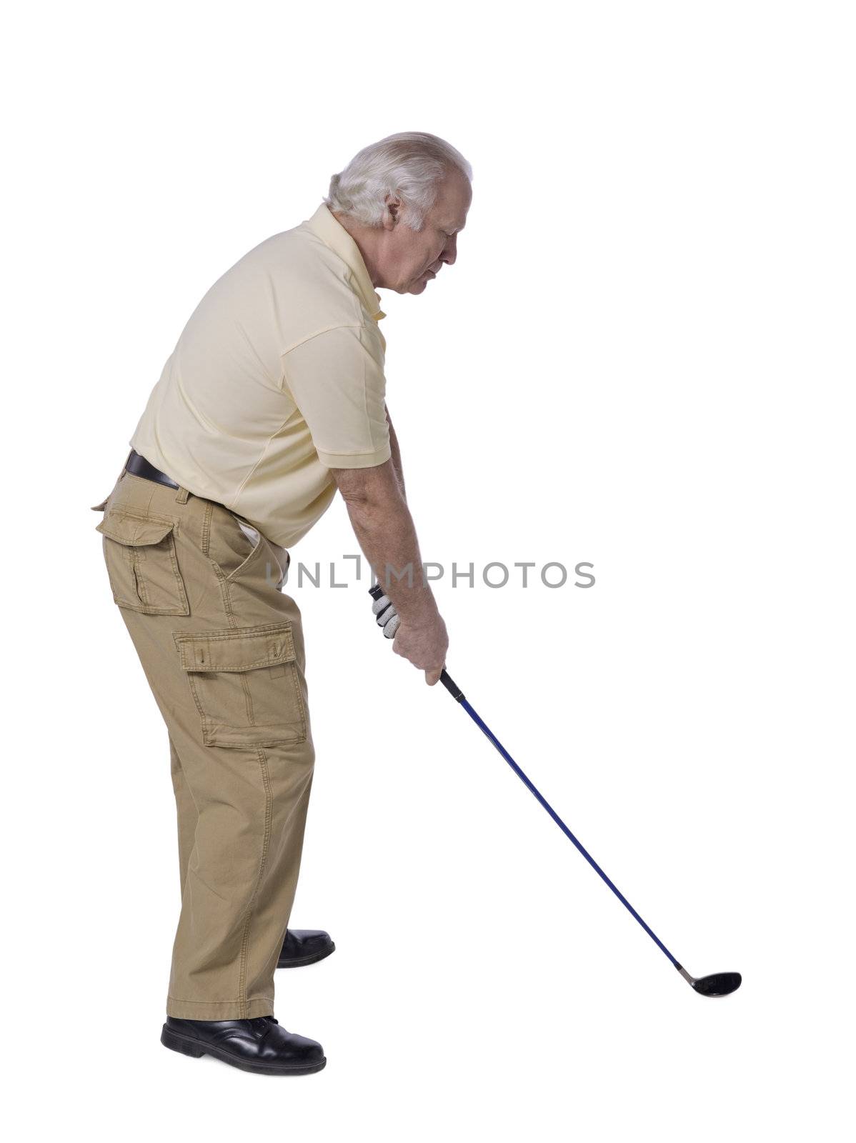 Old male golfer getting ready to hit the ball