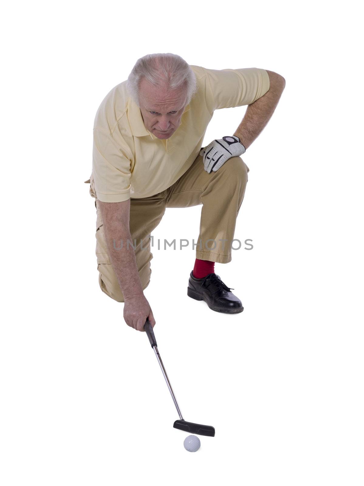 Portrait of senior man playing golf against white background