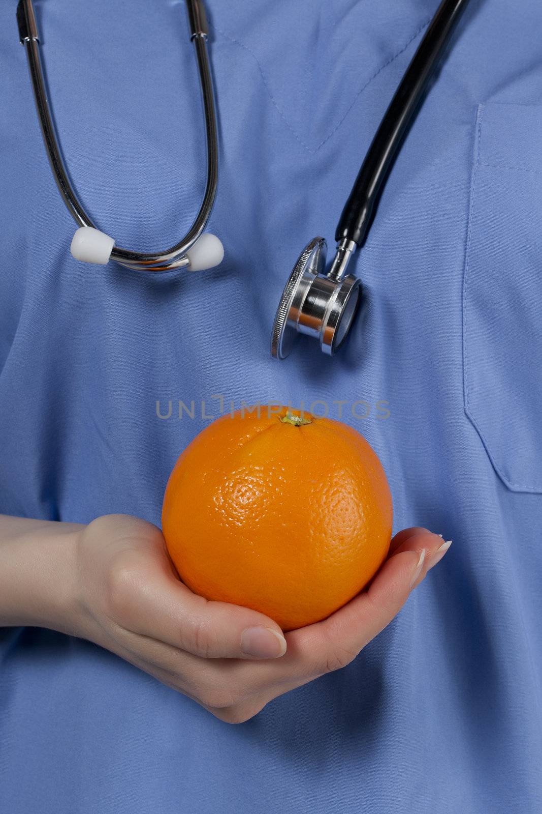 Close-up image of a nutritionist holding orange fruit