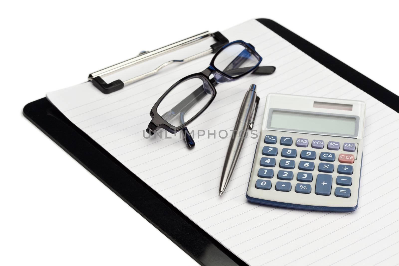 Angled note pad, pen, glasses and pocket calculator on a white background