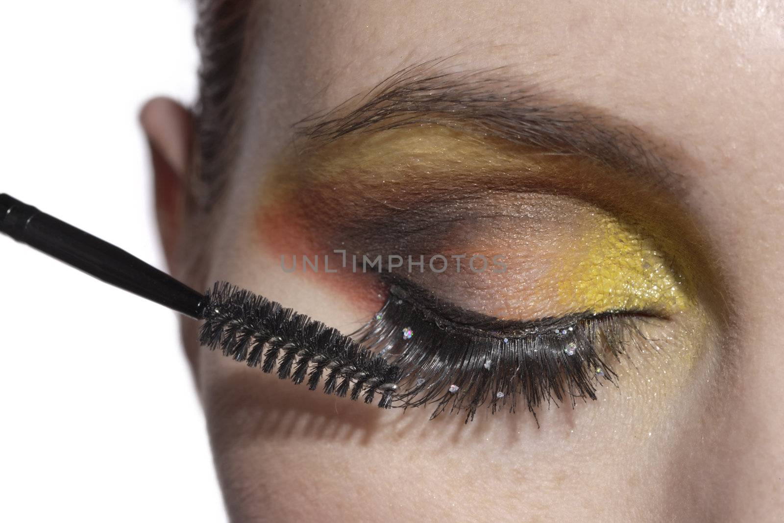 Closeup woman applying eye mascara