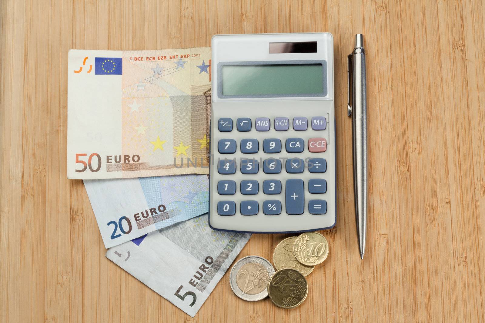 Money with pen and pocket calculator on a desk
