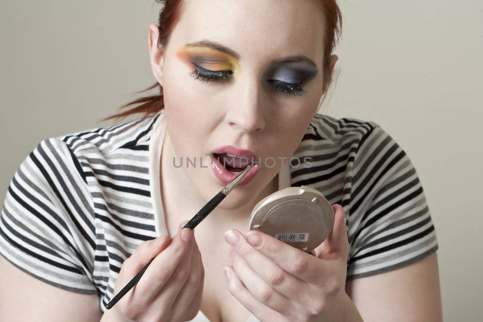 Image of woman applying lipstick 