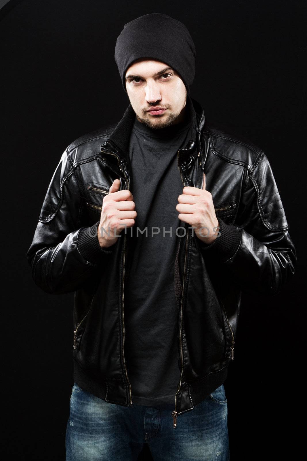 Handsome young man in black leather jacket, studio portrait