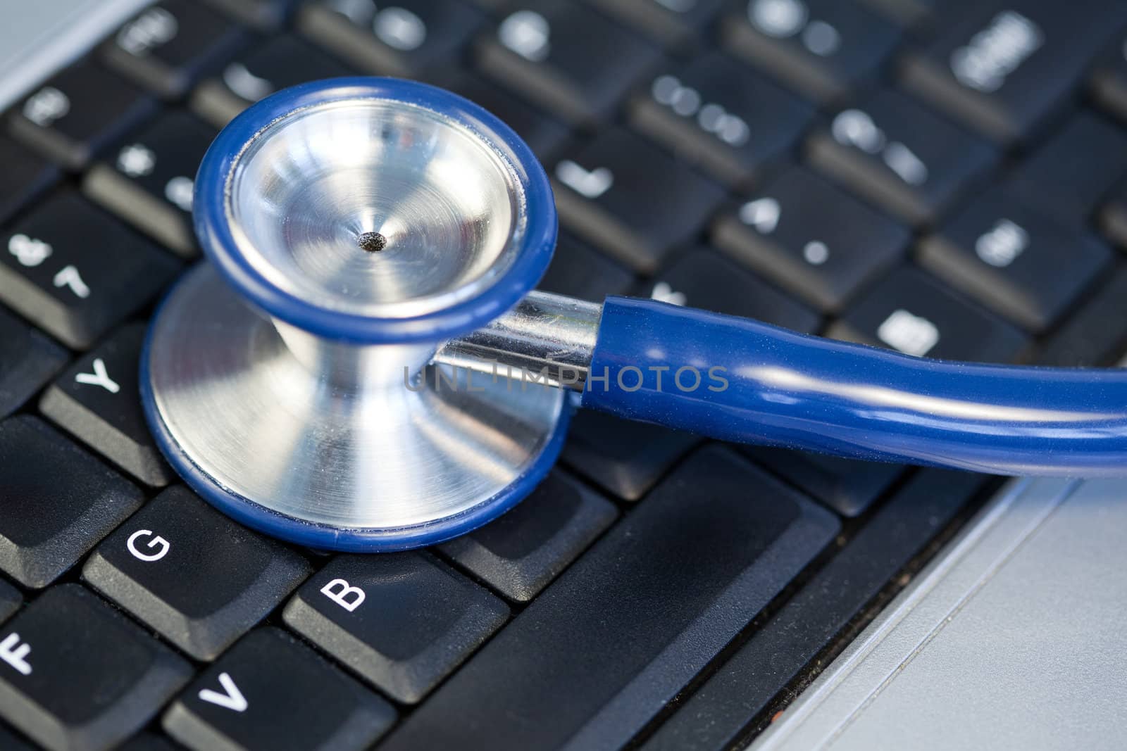 Blue angled stethoscope on keyboard on a blue background