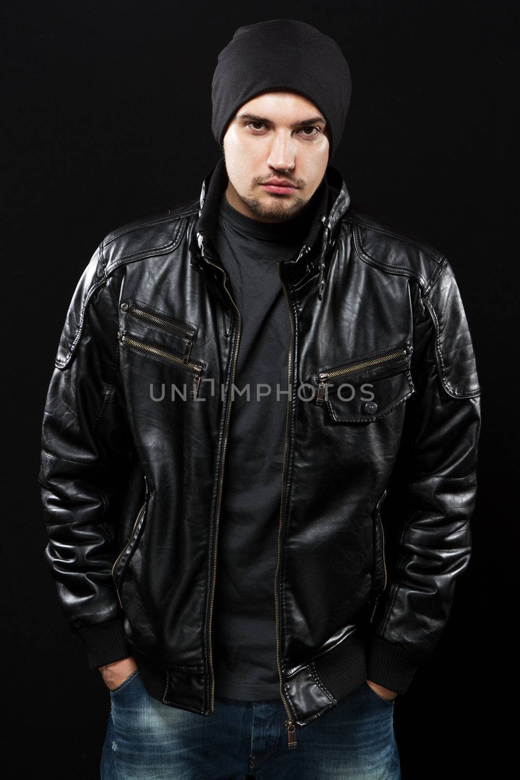 Handsome young man in black leather jacket by Gdolgikh