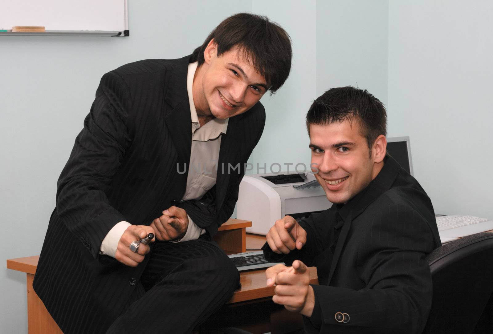 Two joyful businessmen pointing at camera