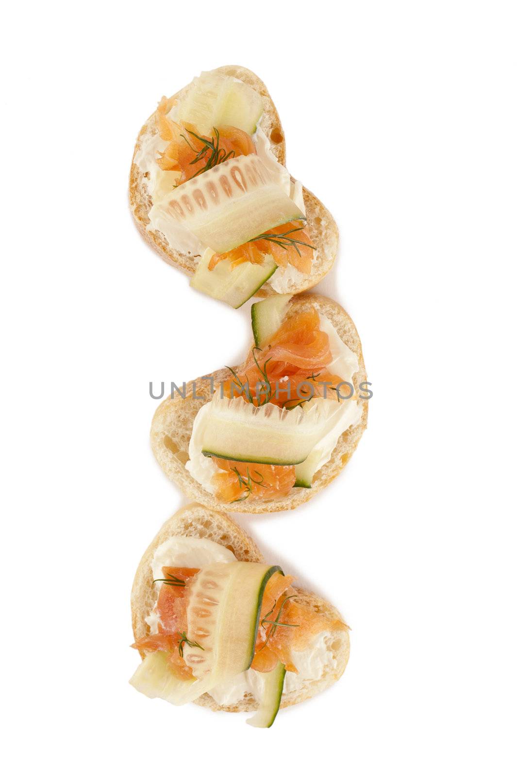 Three slices of bread with butter and smoked salmon against white background 