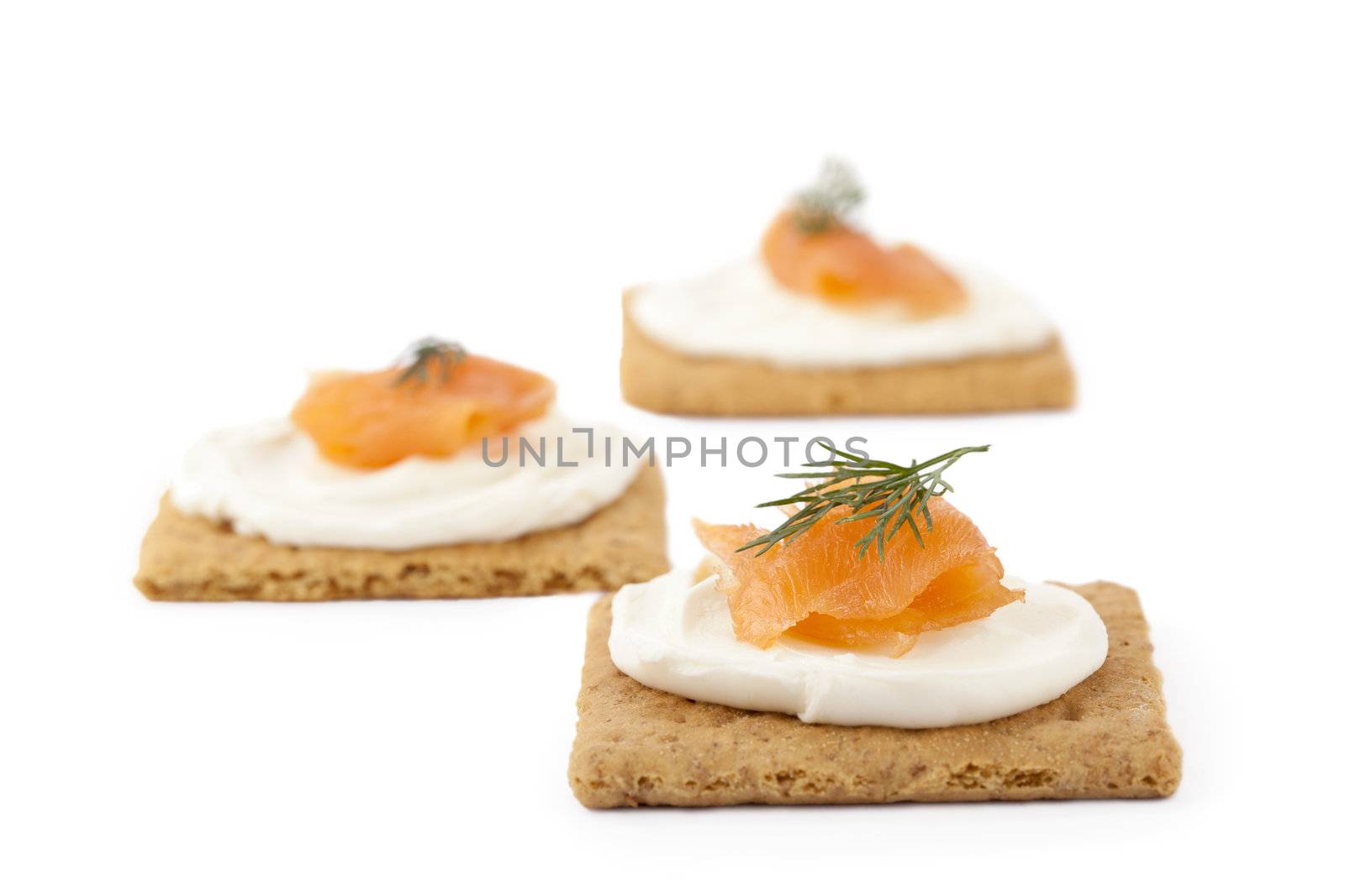 Image of biscuits with smoked salmon and cream cheese top with dill leaves isolated on white 