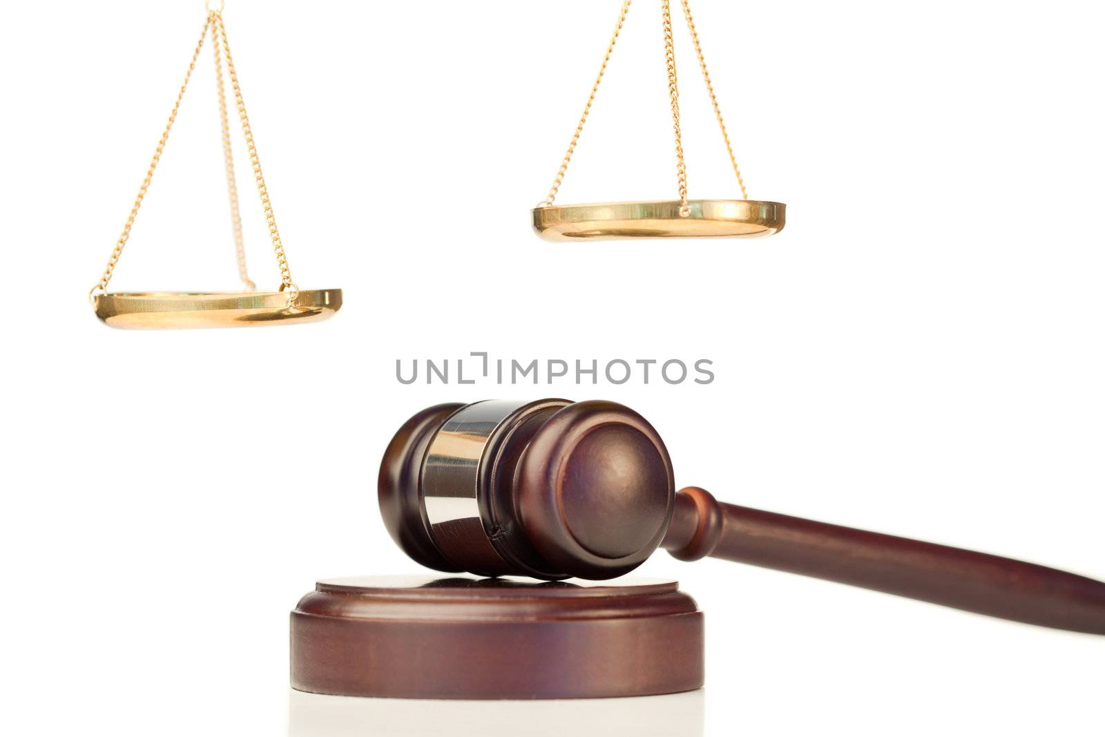 Fixed gavel and golden scale of justice on a white background