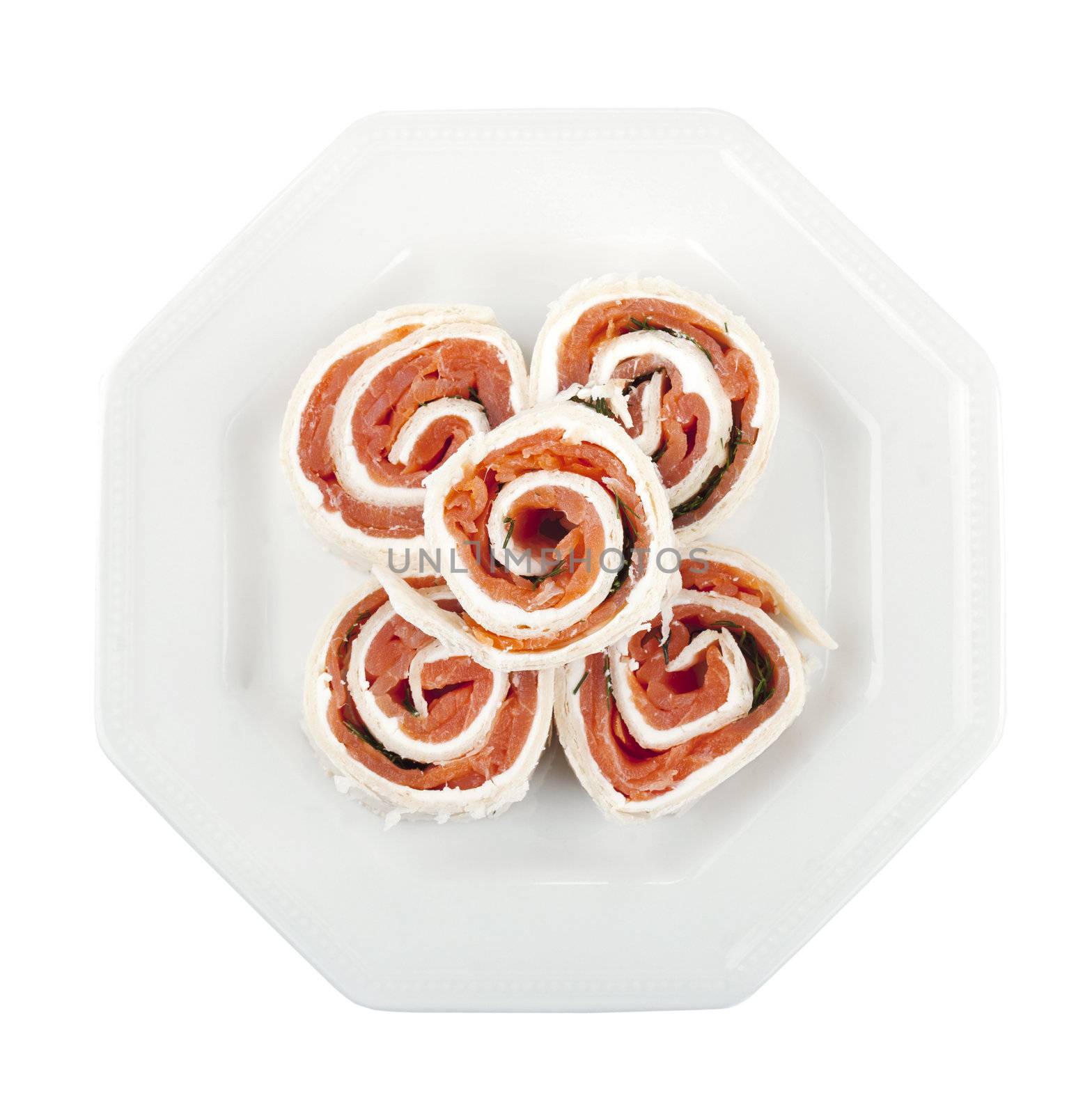 Overhead shot on a plate with smoked salmon rolls against the white background