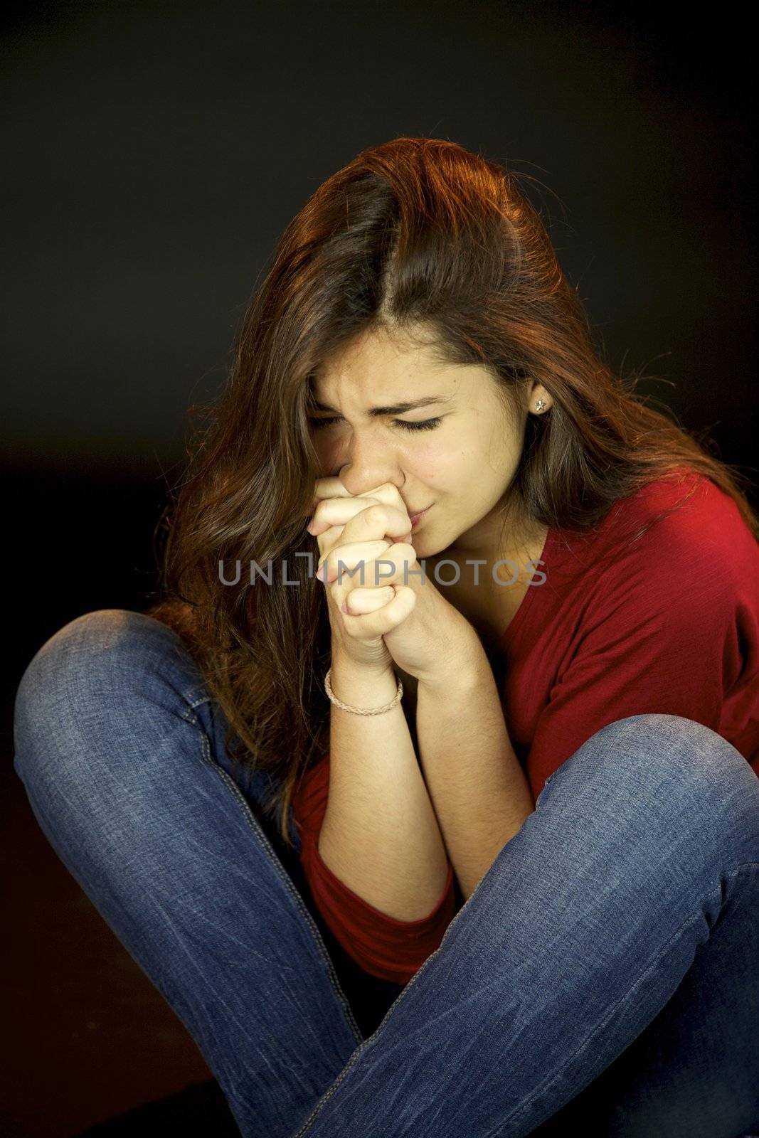 Scared young woman crying and praying
