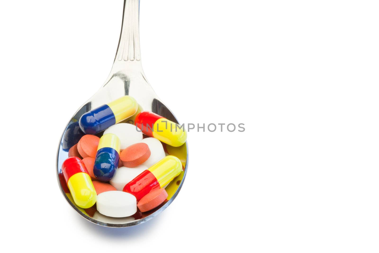 Spoon full of color medicine on a white background