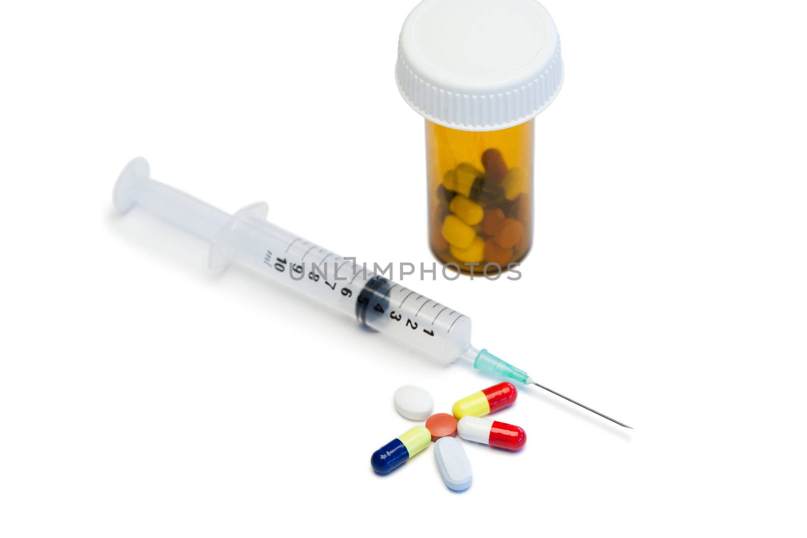 Color pills with box pills and serynge on a white background